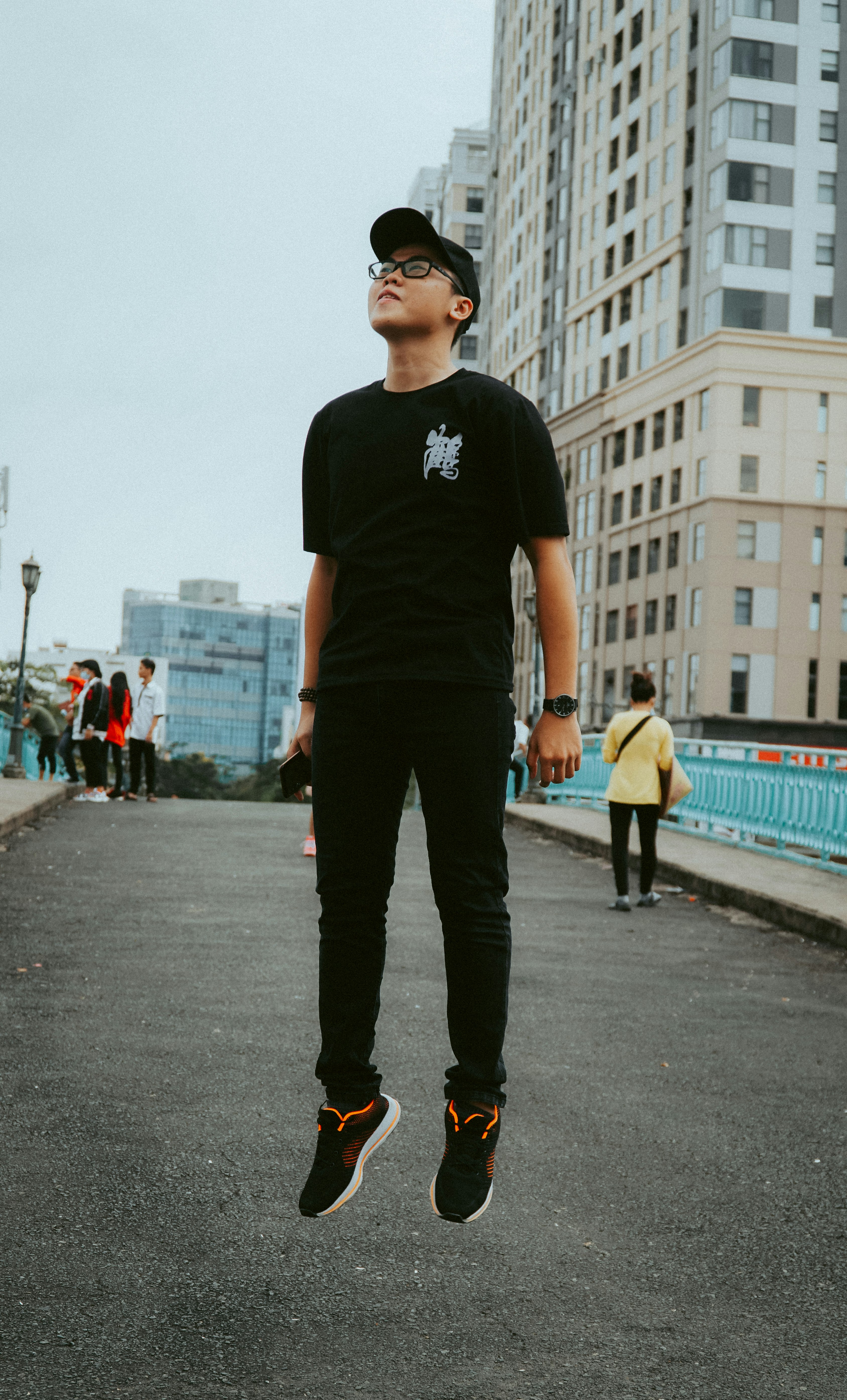 man in black crew neck t-shirt and black pants standing on gray concrete road during